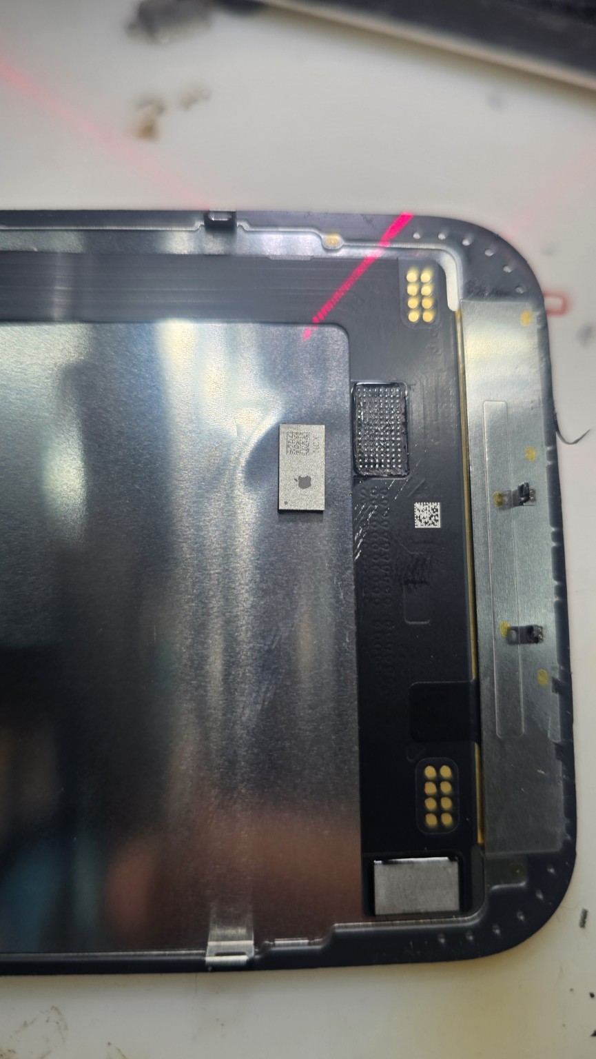 Removed display chip beside its mounting area on an iPhone 16 Plus screen assembly